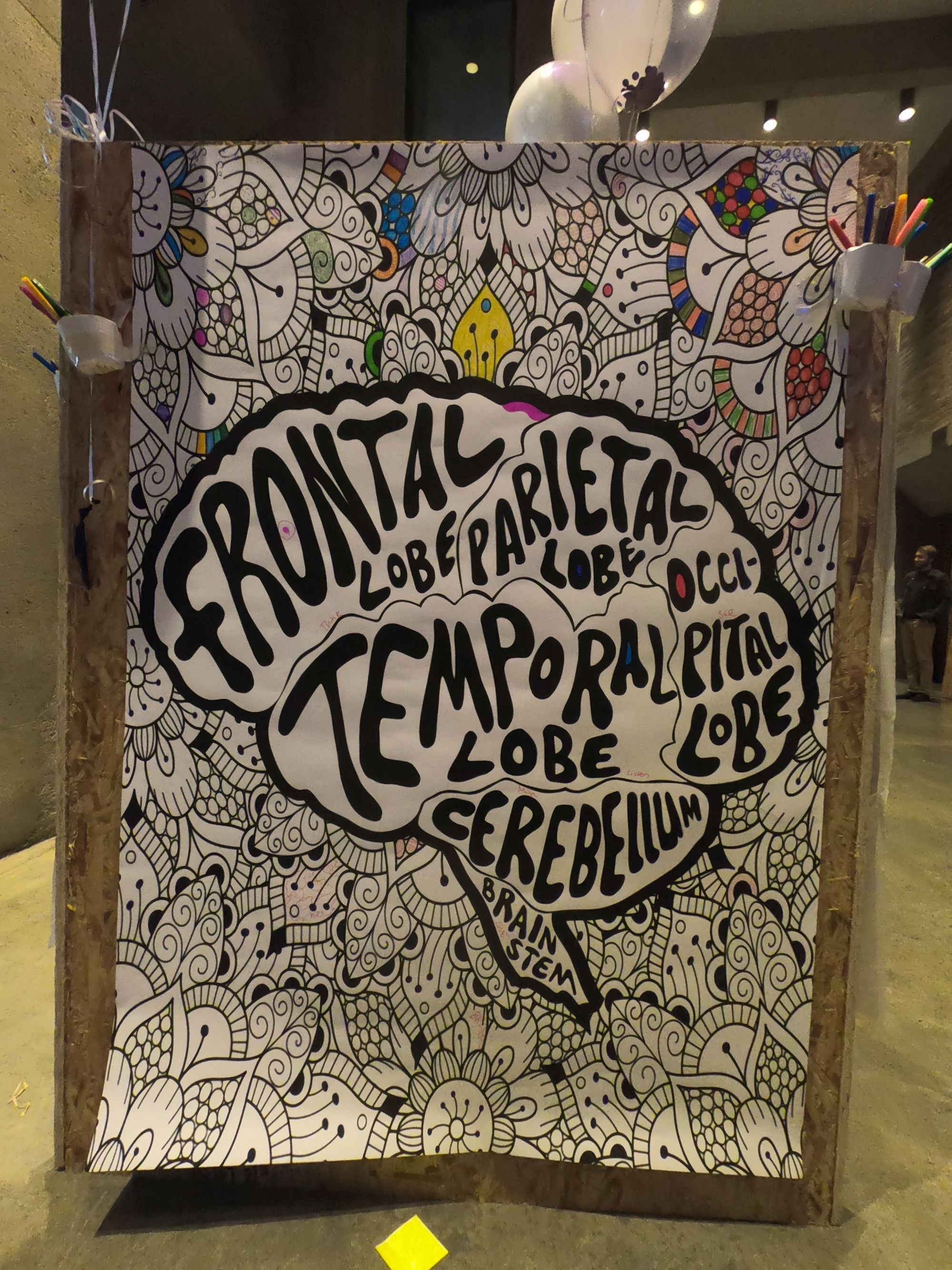 The bottom center image displays an intricate artistic piece in black ink, featuring a brain with the four lobes labeled, as well as intricate designs surrounding it, that attendees filled in with color before the panel discussion.