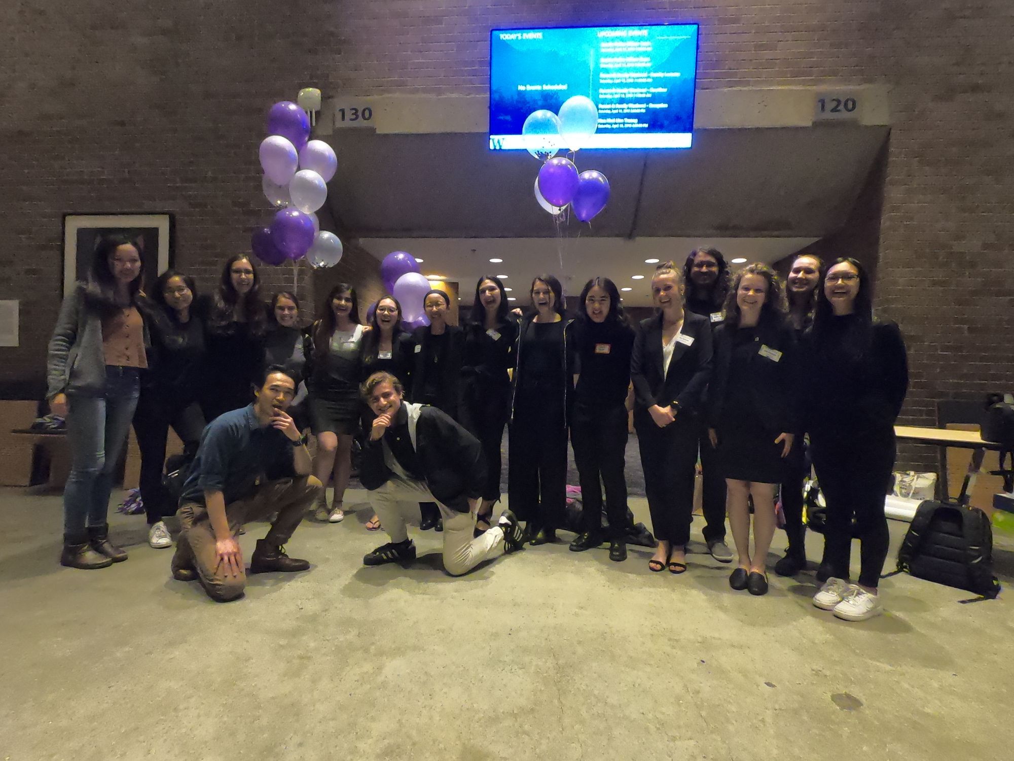 In bottom left image, the EWN planning committee smiles, arranged for a group photo in the lobby of Kane Hall outside the doors of the auditorium, with purple and white balloons in the background.