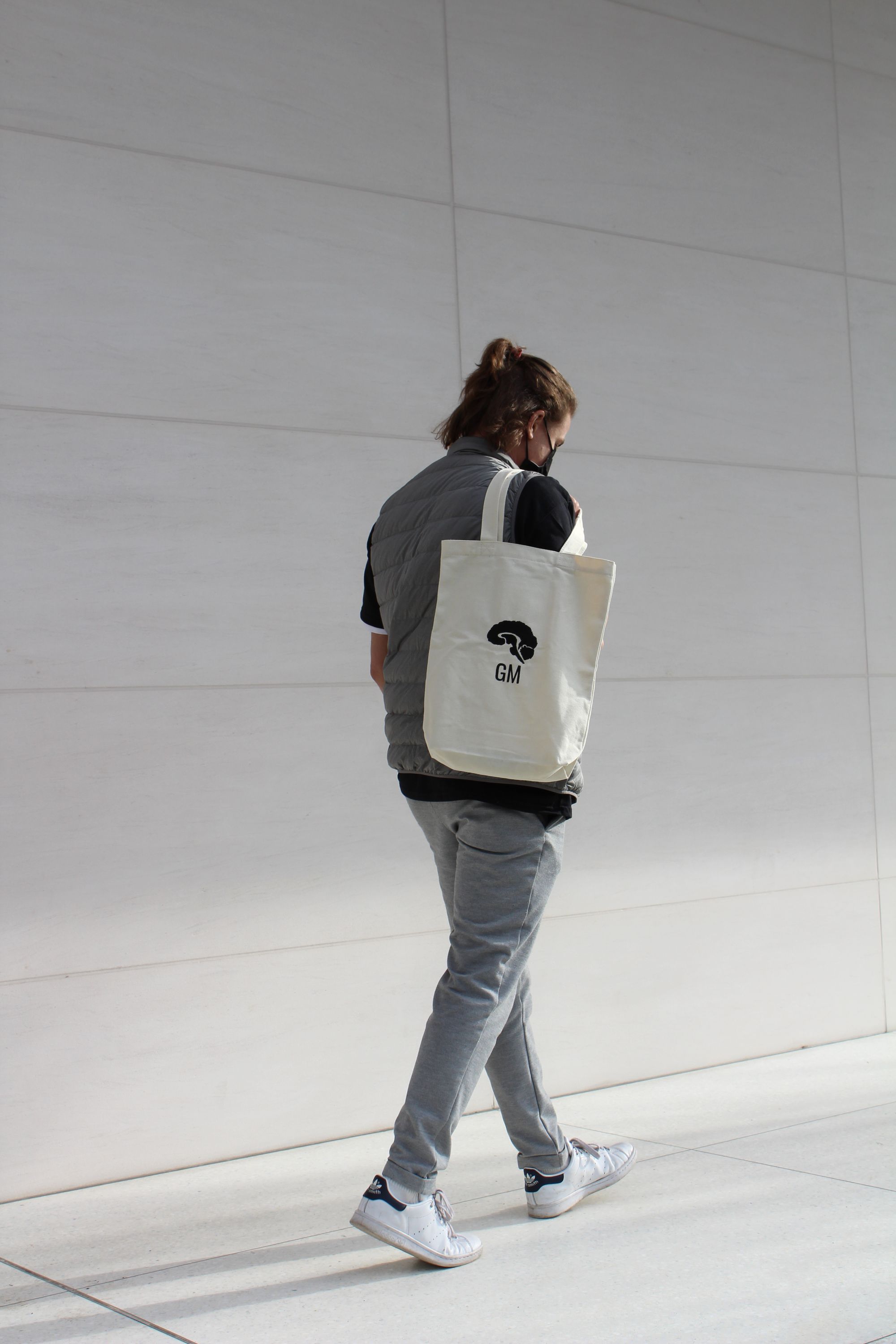 a model carrying a Grey Matters tote bag over one shoulder